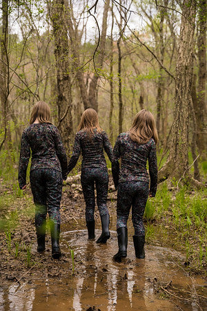 girls walking through woods wearing camo